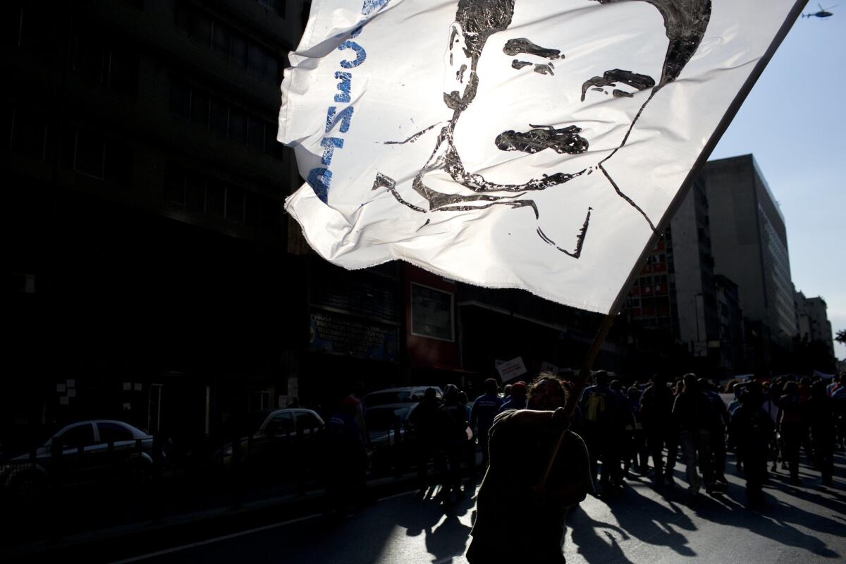 A demonstrator waves a flag with the image of Venezuelan President Nicolas Maduro at a rally in support of the government in Caracas on Tuesday.