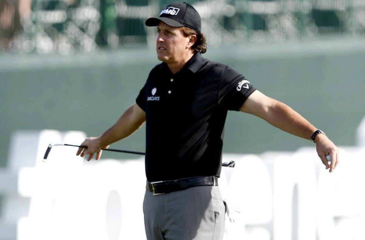 Phil Mickelson stretches on the 17th hole during the first round of the Waste Management Phoenix Open on Thursday, Jan. 30, 2014, in Scottsdale, Ariz.