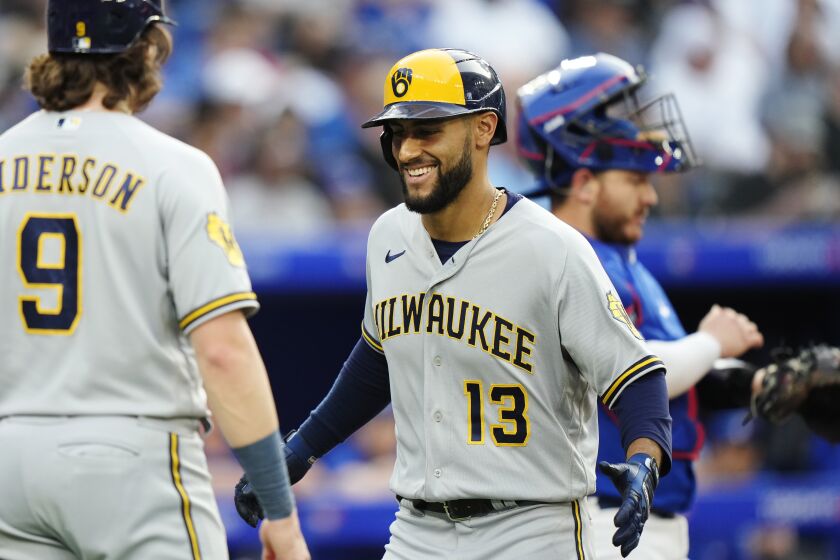 Milwaukee Brewers' Abraham Toro (13) celebrates his two-run home run against the Toronto Blue Jays with Brian Anderson (9) during the second inning of a baseball game Wednesday, May 31, 2023, in Toronto. (Frank Gunn/The Canadian Press via AP)