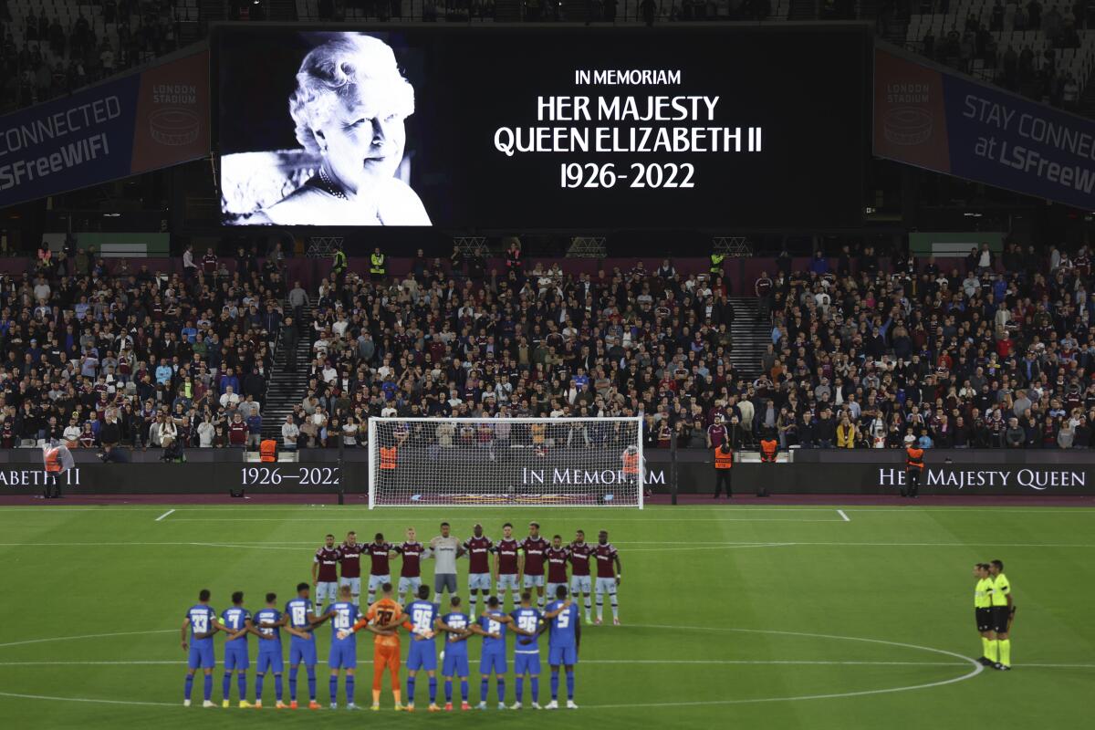 Team players stand on the pitch during minutes silence following the death of Queen Elizabeth II prior the Group B Europa Conference League soccer match between West Ham and FCSB Steaua Bucharest at London Stadium in London, Thursday, Sept. 8, 2022. (AP Photo/Ian Walton)