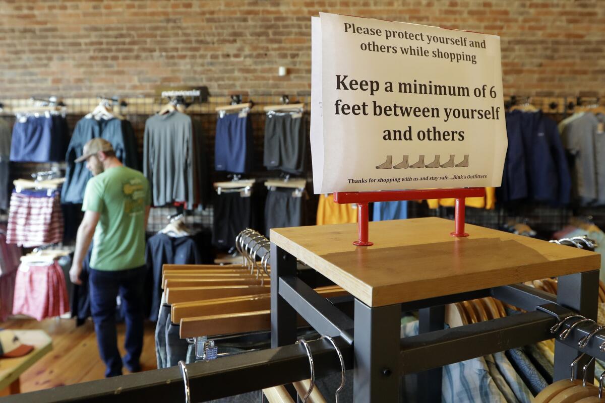 A sign reminding customers of social distancing is posted in the Bink's Outfitters store Wednesday in Murfreesboro, Tenn.