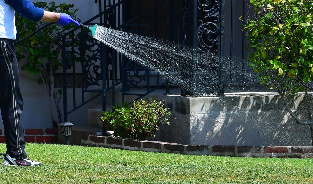 A person waters their lawn.