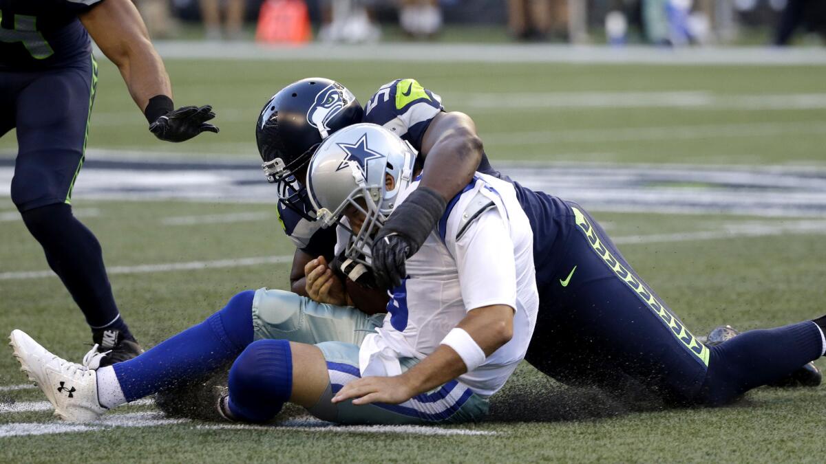 Cowboys quarterback Tony Romo left Thursday night's game after getting tackled on this play by Seattle's Cliff Avrill.