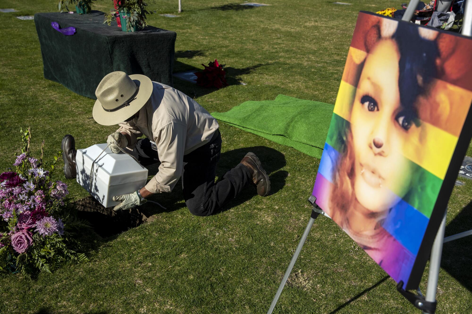 A cemetery worker places an urn in a grave at a memorial service at Desert Memorial Park in Cathedral City.