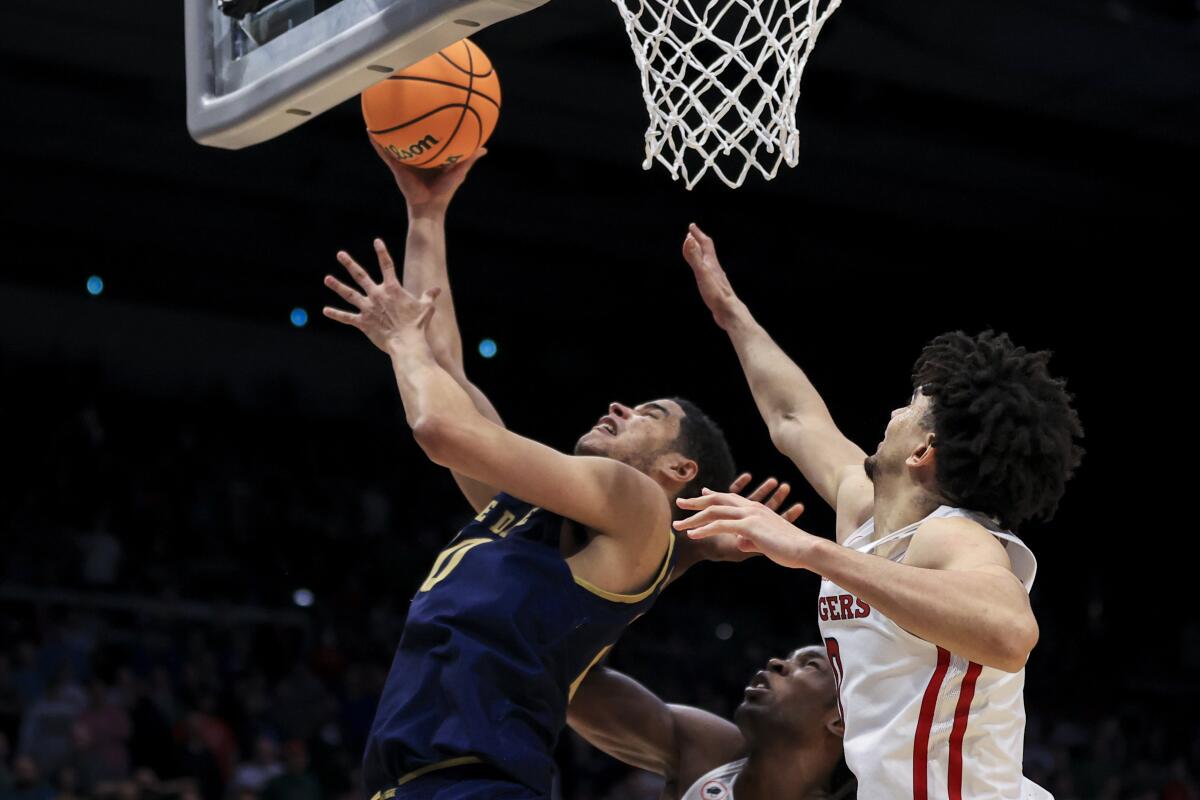 Notre Dame's Paul Atkinson Jr. scores against Rutgers' Clifford Omoruyi and Geo Baker.