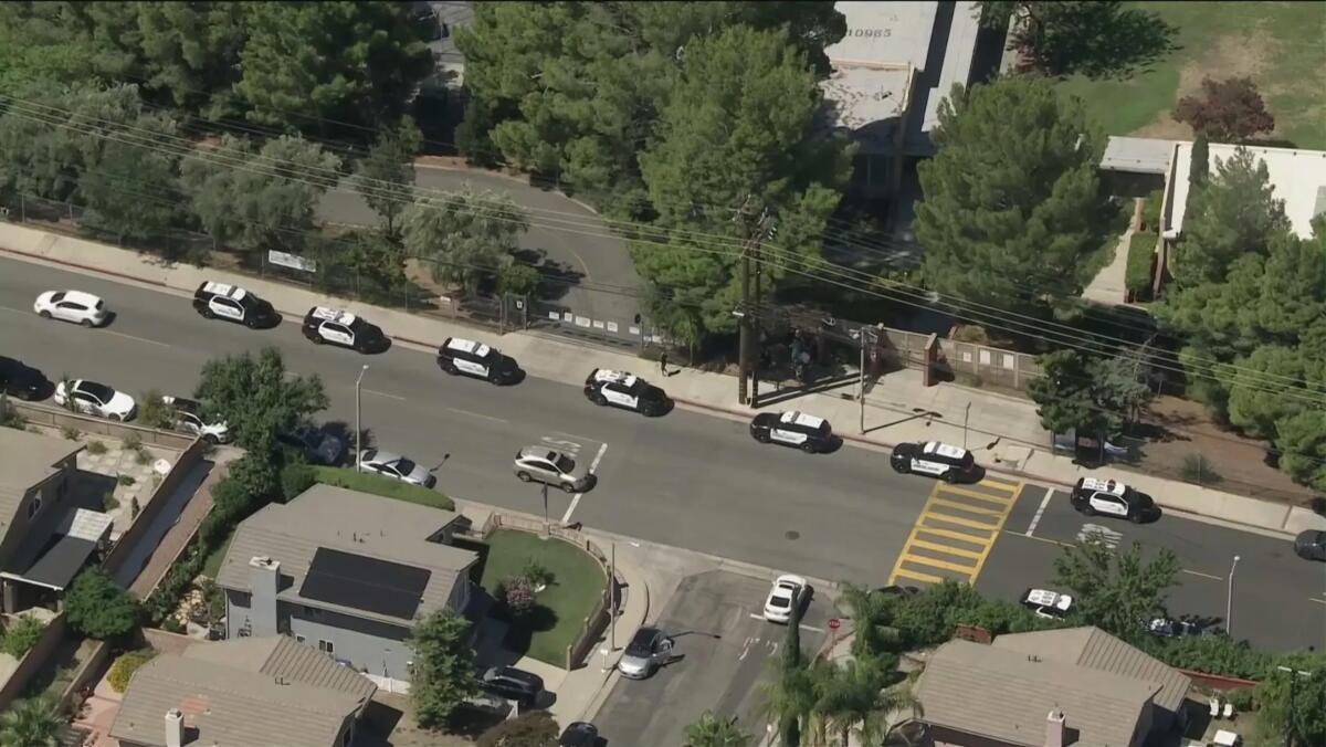 Police cars outside a school seen from an aerial view.