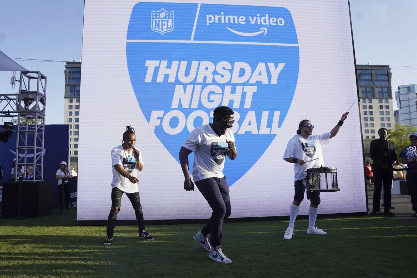 FILE - Robert "Bojo" Ackah, center, and Fik-Shun, left, perform during the announcement of the first Thursday Night Football on Prime Video matchup featuring the San Diego Chargers at Kansas City Chiefs at the 2022 NFL Draft on Thursday, April 28, 2022 in Las Vegas. The Thursday night, Sept. 15 game between the Los Angeles Chargers and Kansas City Chiefs kicks off Amazon Prime Video's 11-year agreement with the NFL to carry “Thursday Night Football". (AP Photo/Vera Nieuwenhuis, File)