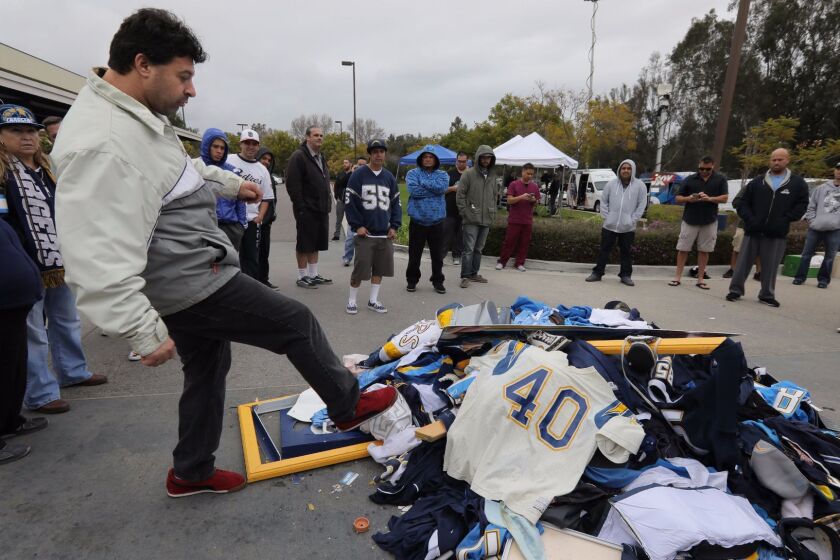 January 12, 2016_San Diego, California_USA_| At Chargers headquarters on Murphy Canyon Road angry Chargers fan Chris Githens kicks at a pile of discarded Chargers gear in front of the building's entrance. |_Photo Credit: Photo by Charlie Neuman