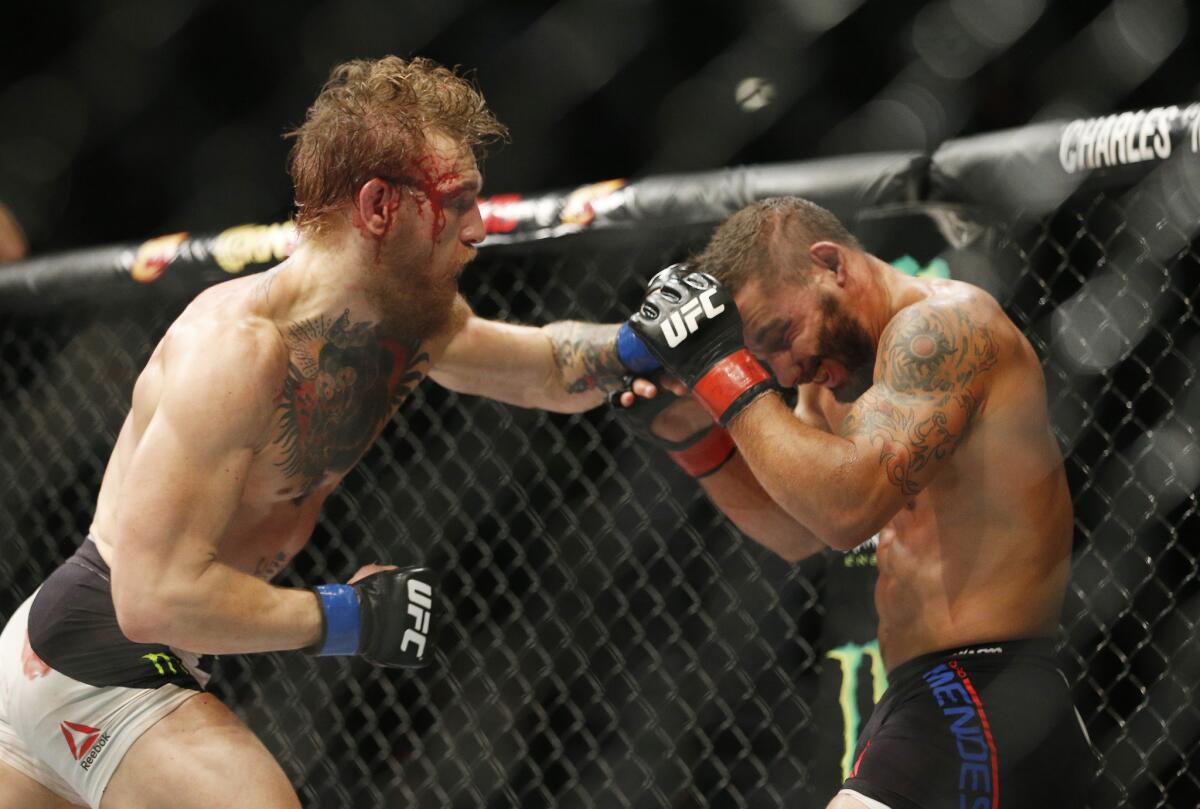 Conor McGregor strikes Chad Mendes during their interim featherweight title fight on Saturday night at UFC 189 in Las Vegas.