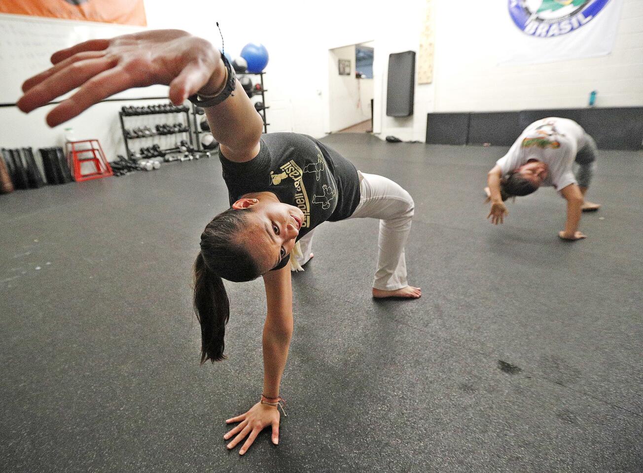 Isabela Benitez, of Sherman Oaks, moves across the floor doing a martial arts sequence in a capoeira class that, this evening, focused on preparing for an upcoming rank advancement at Legacy Brazilian Jiu-Jitsu and Mixed Martial Arts in Burbank on Friday, August 31, 2018. According to an online dictionary, capoeira is a sport combining rhythmic dance, martial-arts, and acrobatic movements that originated in 16th-century Brazil among African slaves who practiced it as a form of self-defense disguised as dance.