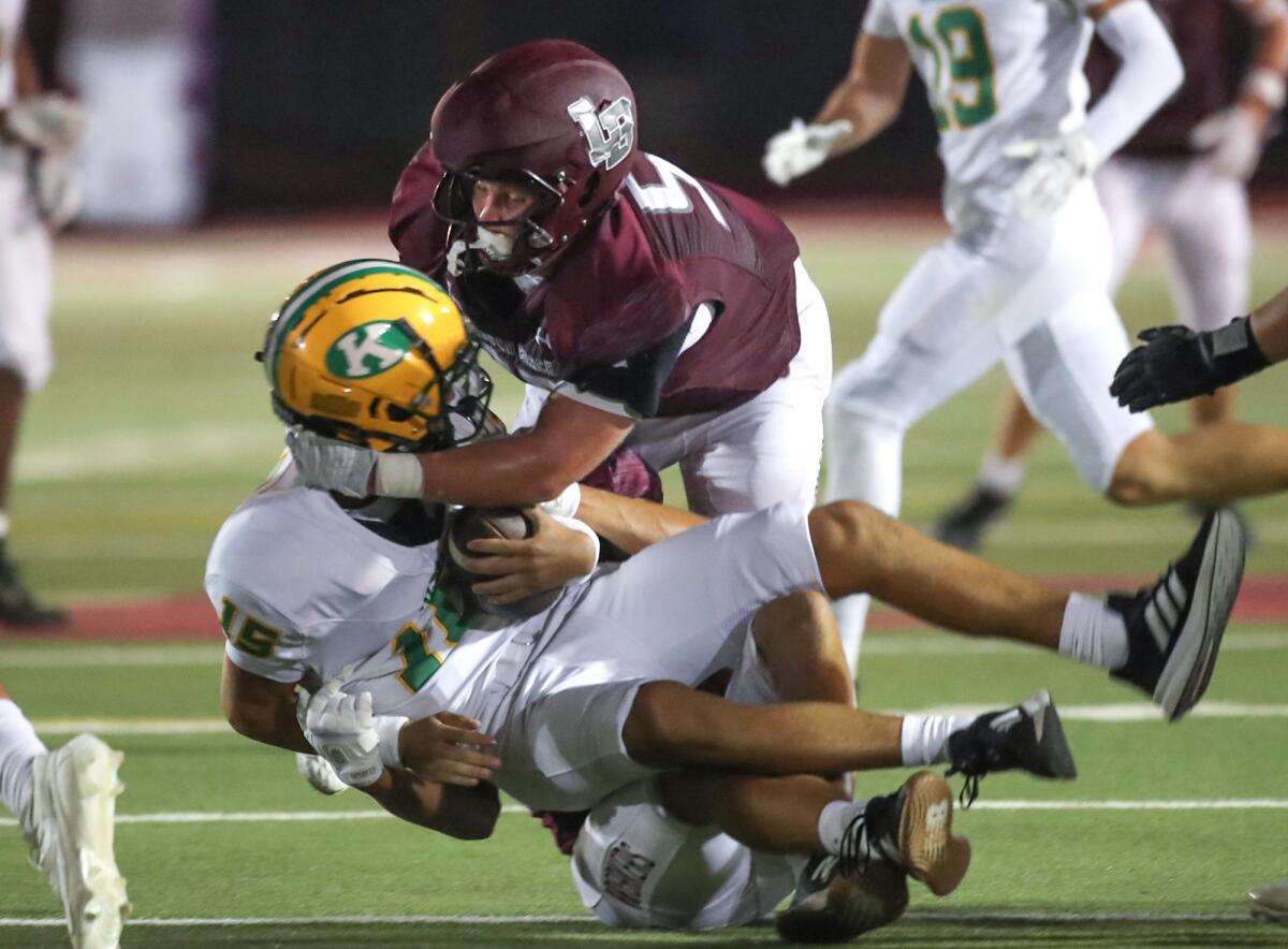 Hudson Mills and Charlie Kelly of Laguna Beach take down Kennedy quarterback Derek Almazan (15) for a sack.