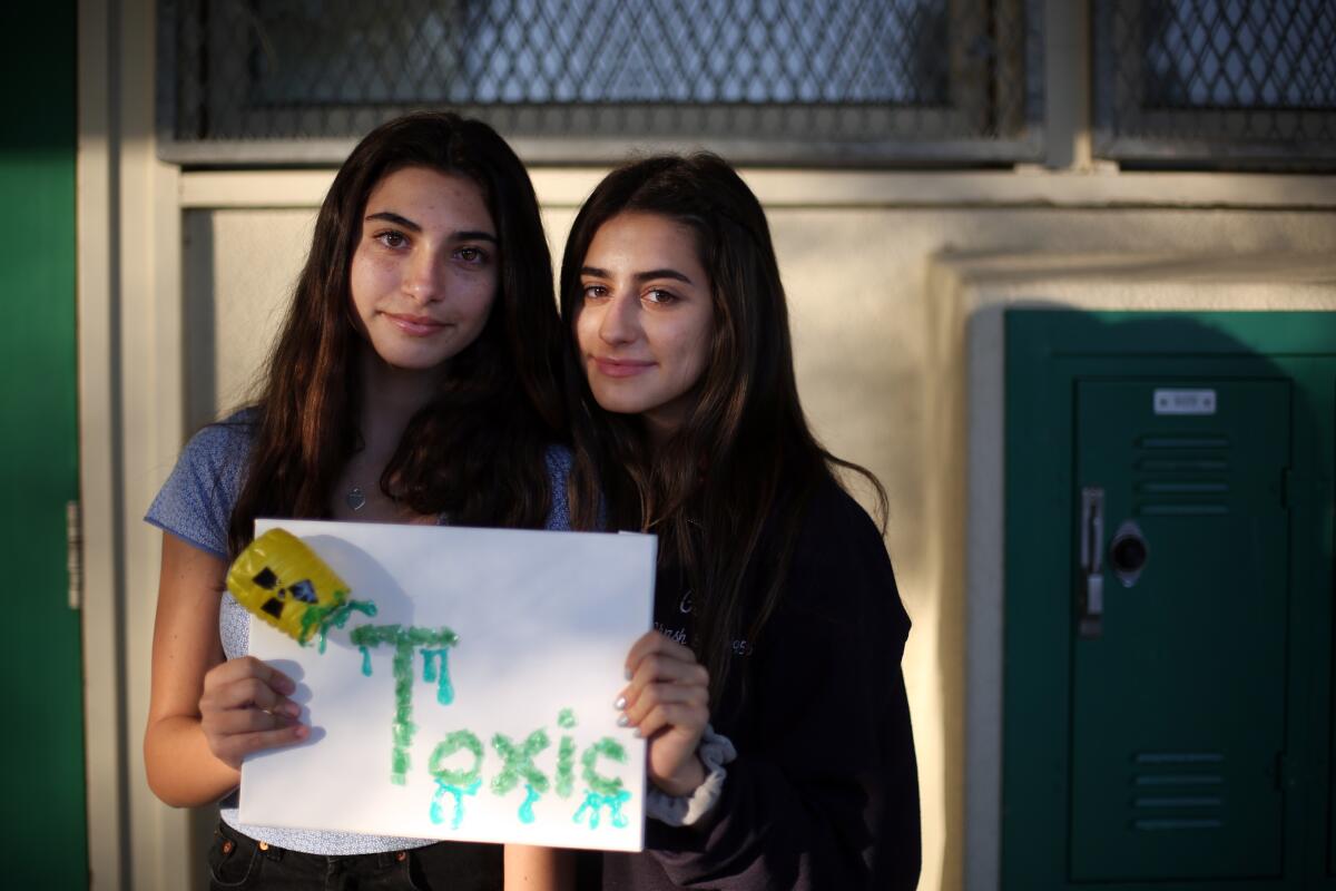 Jackie Larsen, left, and Gaby Krasny hold artwork they created in chemistry class made from collected plastic. They are in teacher Jeanette Chipps' class, which incorporates climate change into curriculum and projects.