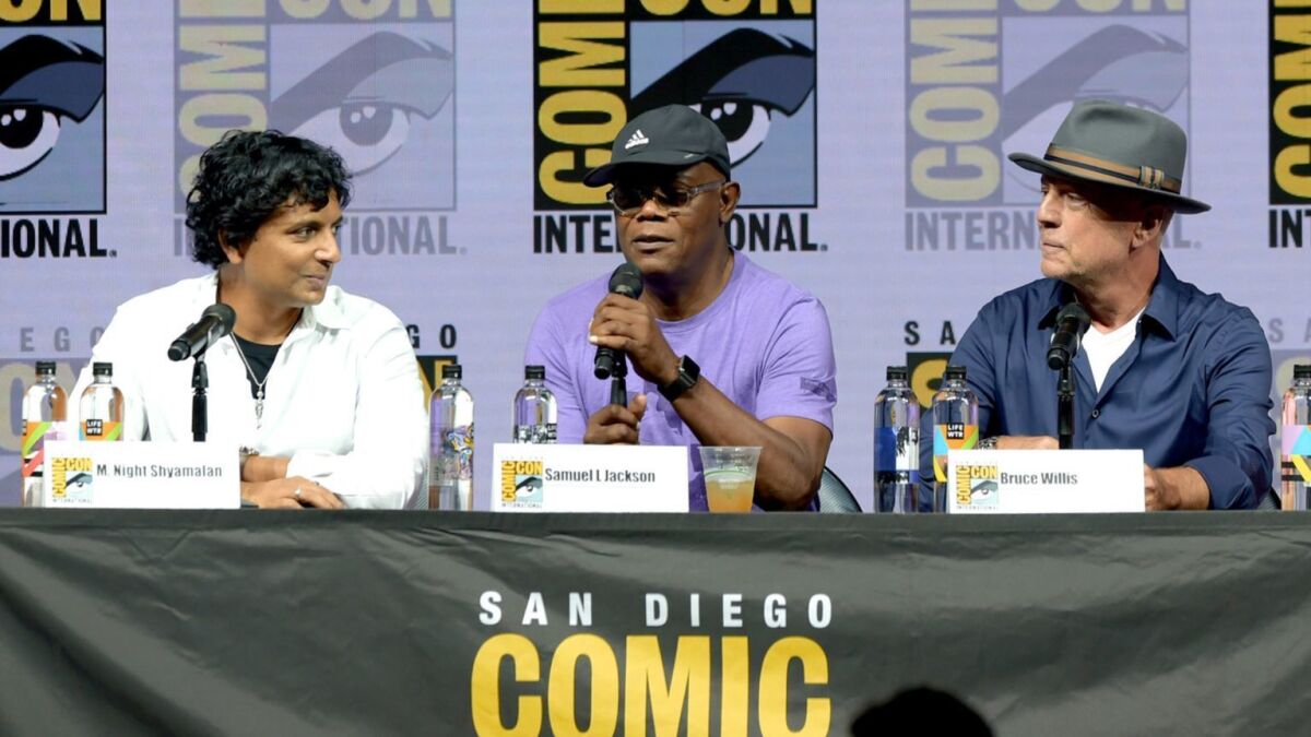 M. Night Shyamalan, left, Samuel L. Jackson, and Bruce Willis onstage at Universal Pictures' "Glass" panel during Comic-Con International 2018.