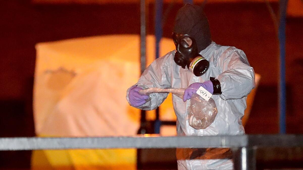 Police officers in protective suits and masks work on Tuesday at the scene of the poisoning of Sergei Skripal in Salisbury, England.