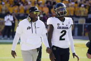 Colorado head coach Deion Sanders, left, talks with his son and starting quarterback Shedeur Sanders (2) prior to an NCAA college football game against Arizona State, Saturday, Oct. 7, 2023, in Tempe, Ariz. (AP Photo/Ross D. Franklin)