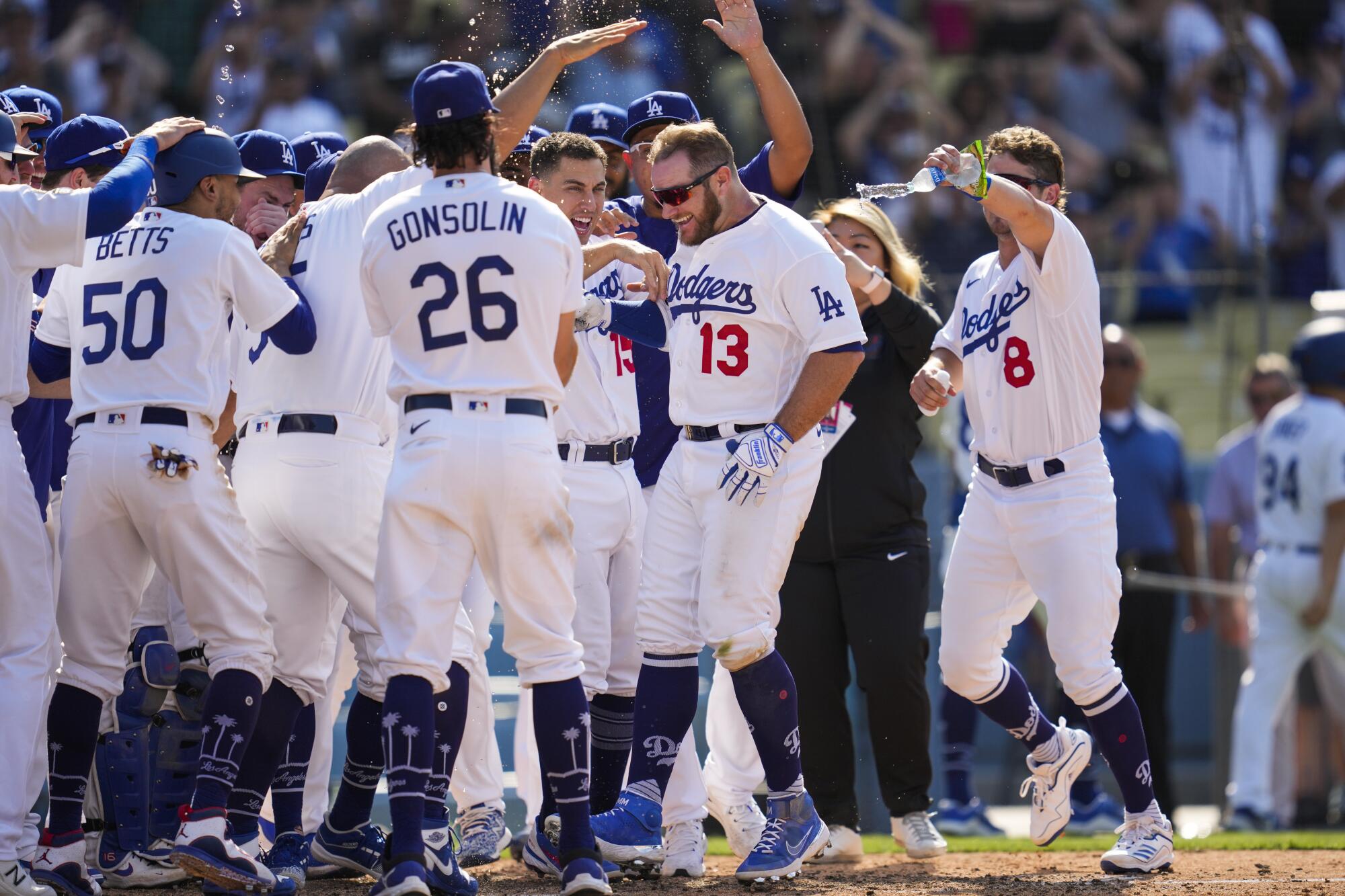 Max Muncy (13) celebrates with his Dodgers teammates after hitting a walk-off home run in a 7-4 victory.