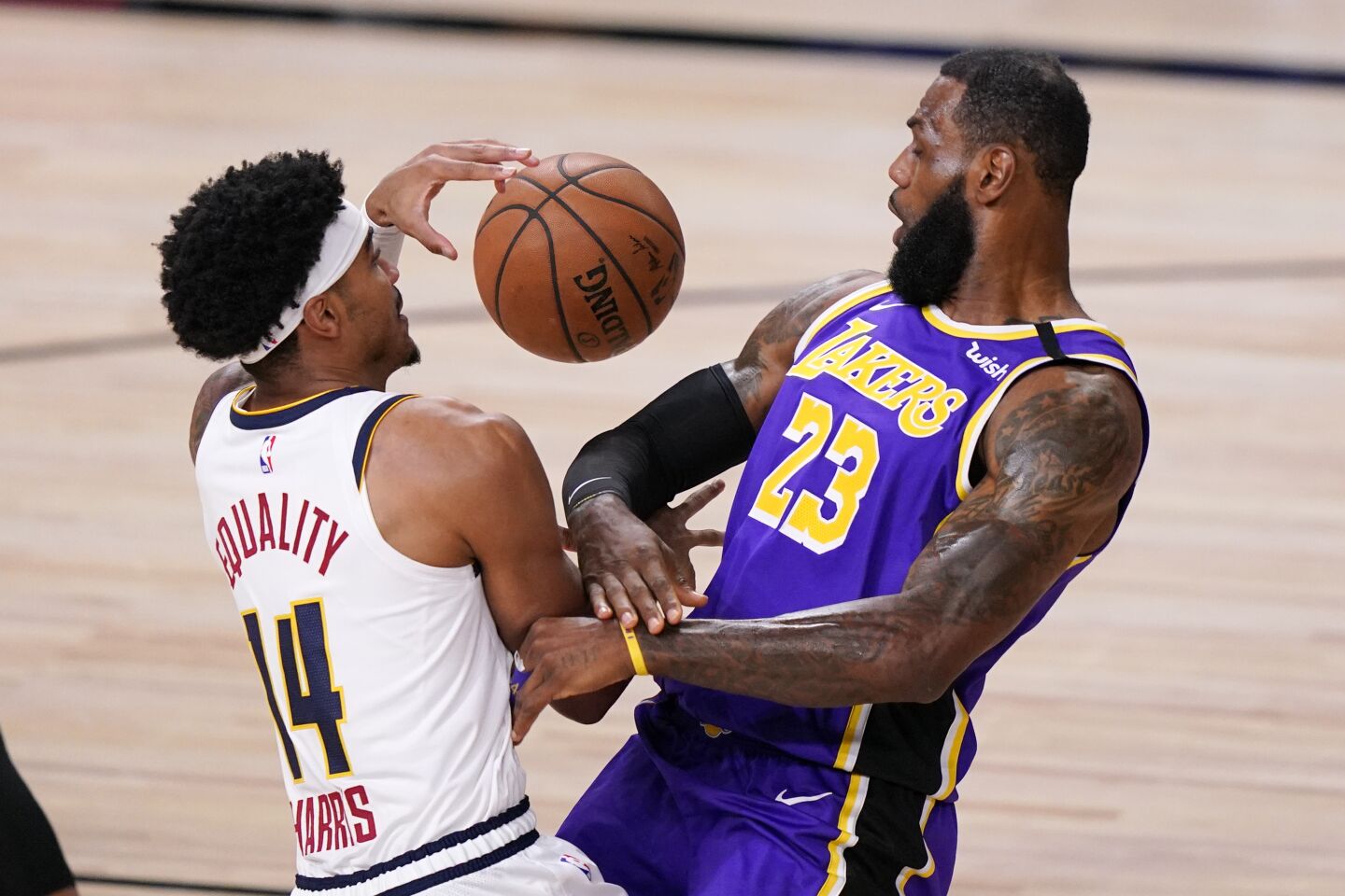 Lakers forward LeBron James takes a charge against Nuggets guard Gary Harris.