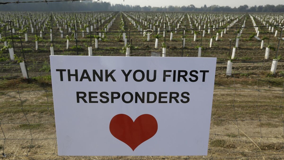 A sign thanking first responders hangs by a newly planted vineyard in Napa. With the winds dying down, fire crews gained ground as they battled wildfires that have devastated California wine country.