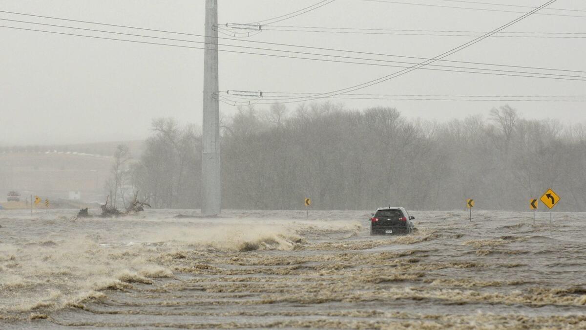 In this March 14, 2019, photo, an abandoned car sits on Industrial Highway in flood waters north of Norfolk, Neb. According to a trooper on scene, the occupant had to be rescued.