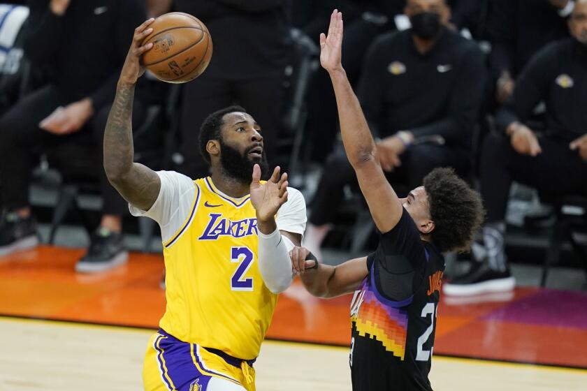 Los Angeles Lakers center Andre Drummond (2) drives past Phoenix Suns forward Cameron Johnson, right, during the first half of Game 2 of their NBA basketball first-round playoff series Tuesday, May 25, 2021, in Phoenix. (AP Photo/Ross D. Franklin)