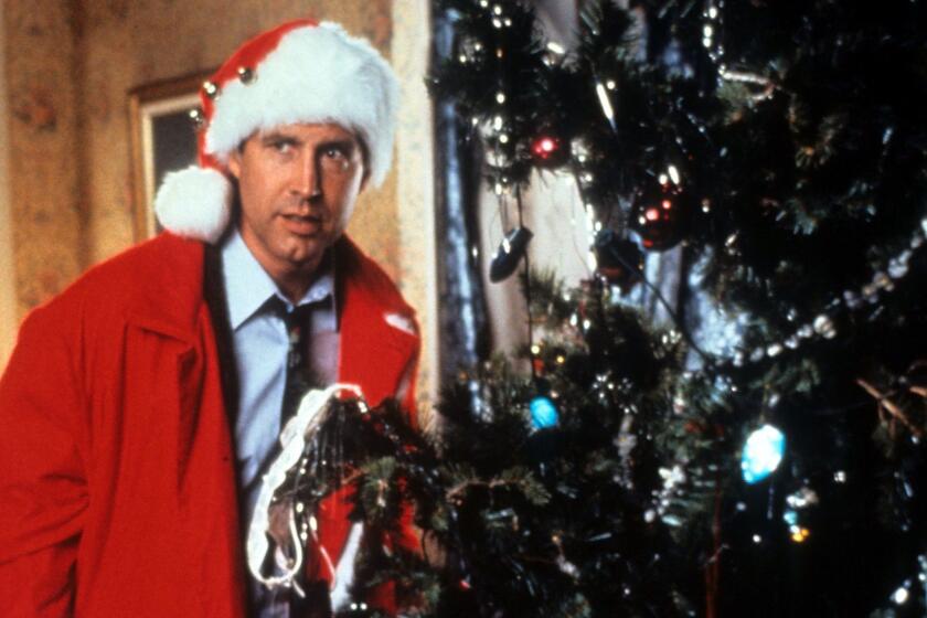 Chevy Chase hides behind the tree in a scene from the film 'Christmas Vacation', 1989. (Photo by Warner Brothers/Getty Images) ** OUTS - ELSENT, FPG - OUTS * NM, PH, VA if sourced by CT, LA or MoD **