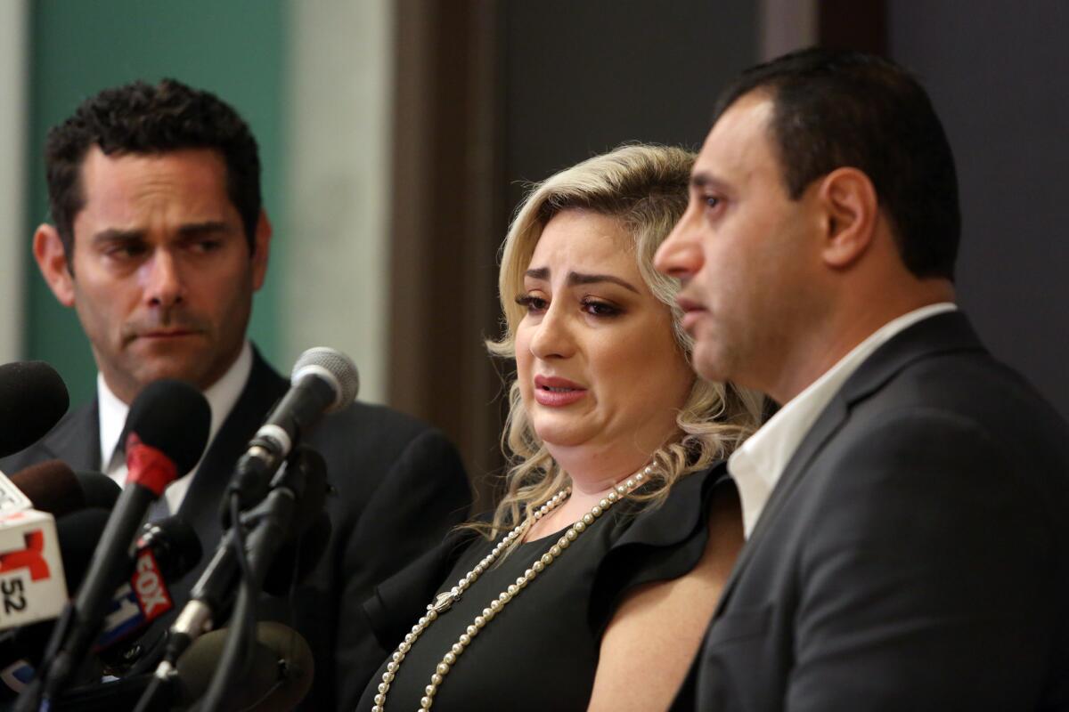 Anni Manukyan, center, speaks with her husband, Ashot Manukyan, right, during a news conference in Los Angeles about the alleged mix-up over a mishandled IVF treatment.