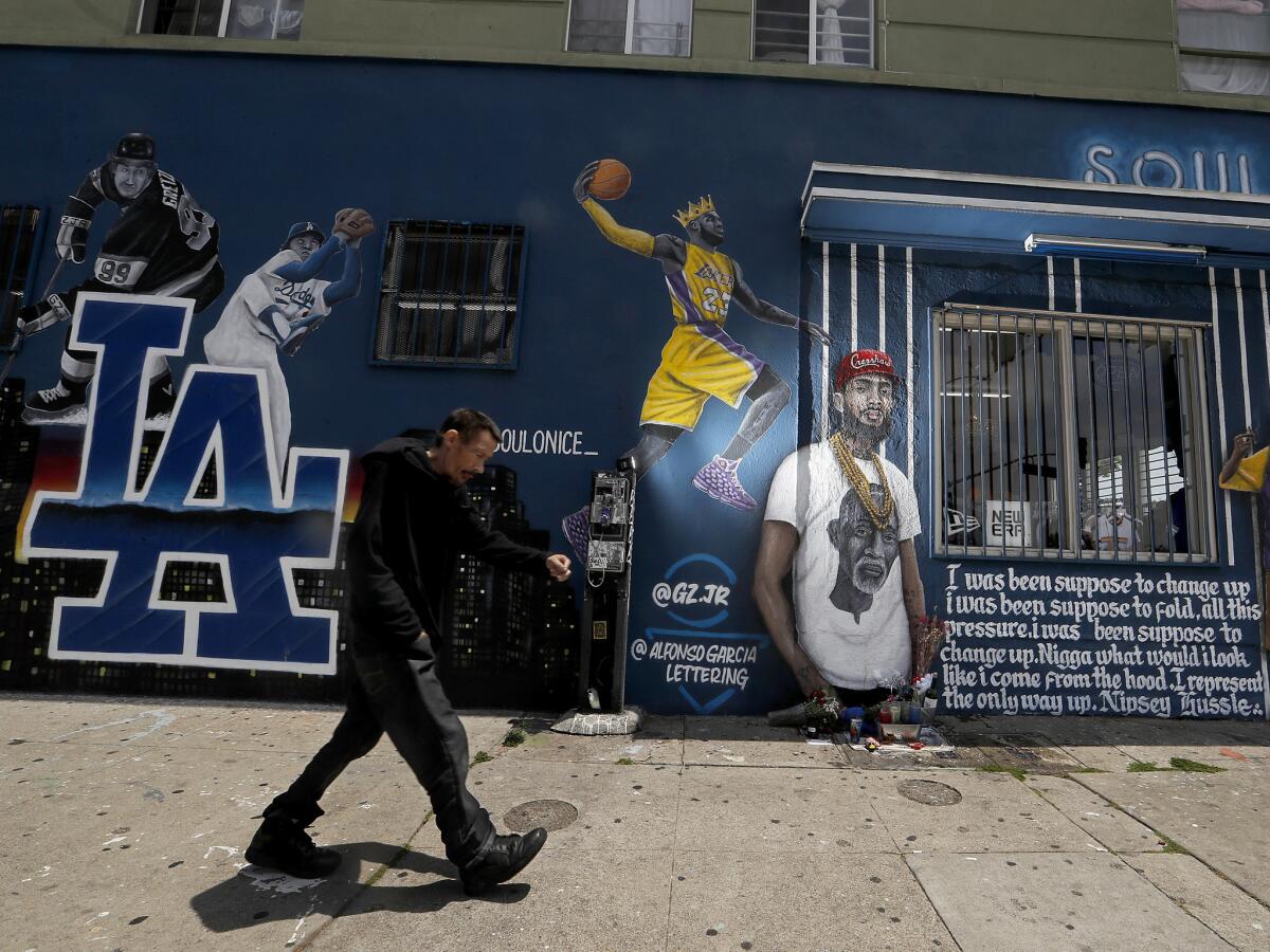 An image of Nipsey Hussle is part of a mural outside a clothing store at 2491 W. Washington Blvd. (Luis Sinco / Los Angeles Times)