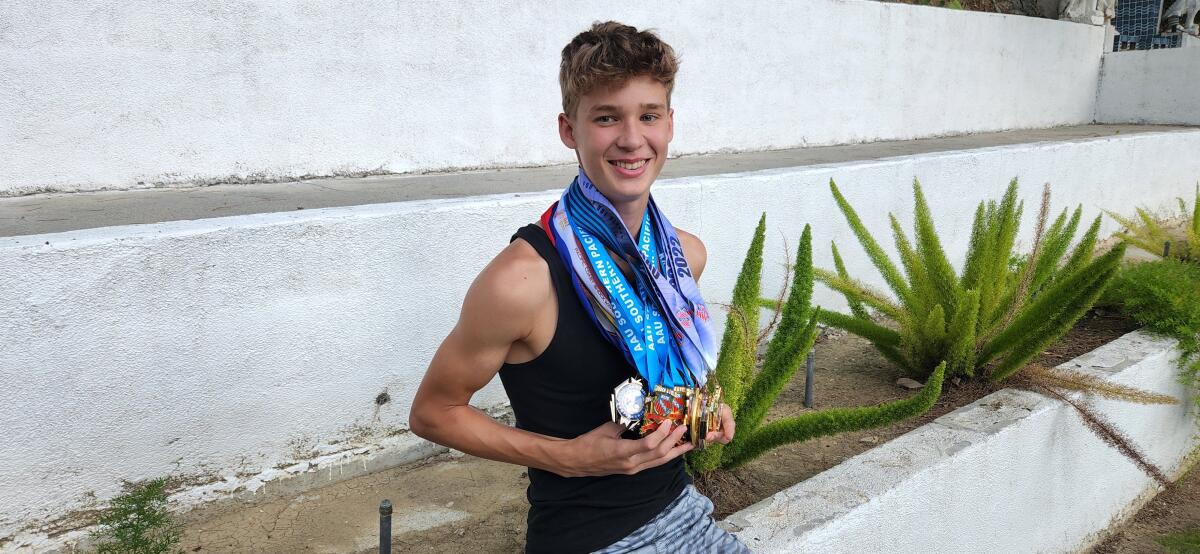 JJ Harel, a freshman high jumper at Chaminade, shows off his 27 medals earned this past year in track and field competitions.