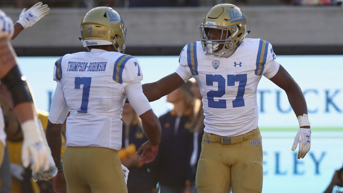 UCLA's Dorian Thompson-Robinson, left, congratulates Joshua Kelley after he ran in for a touchdown against California at California Memorial Stadium on Saturday in Berkeley.