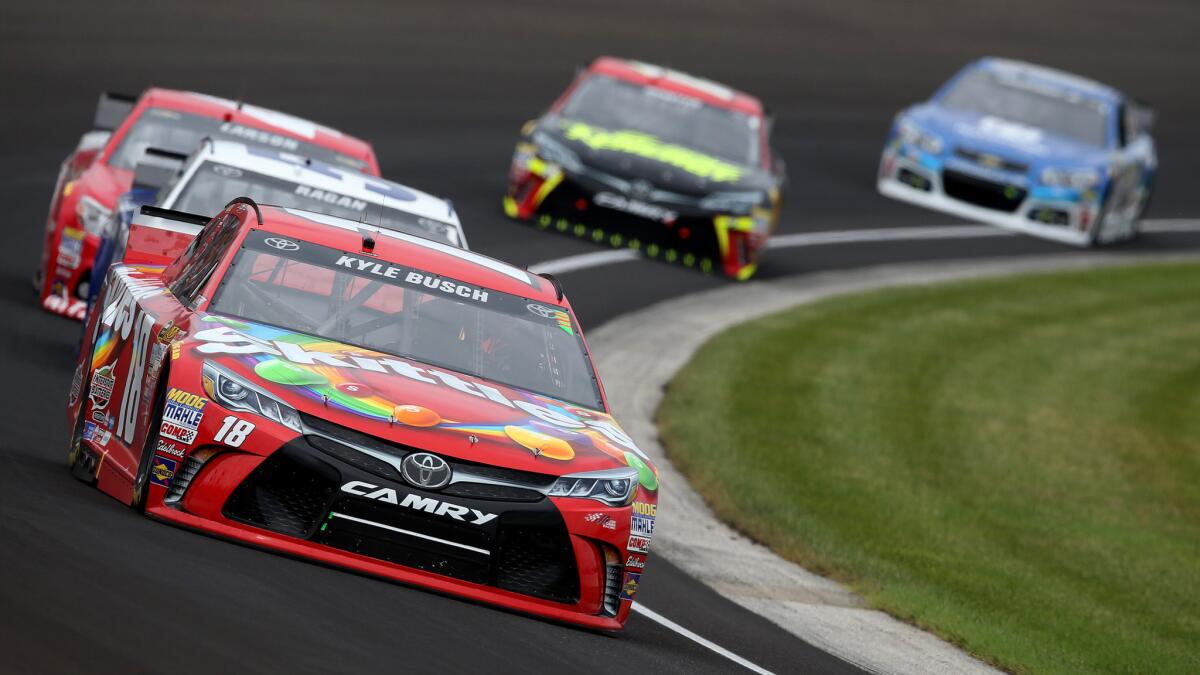 NASCAR driver Kyle Busch leads a pack of cars through a turn during the Brickyard 400 on Sunday at Indianapolis Motor Speedway.