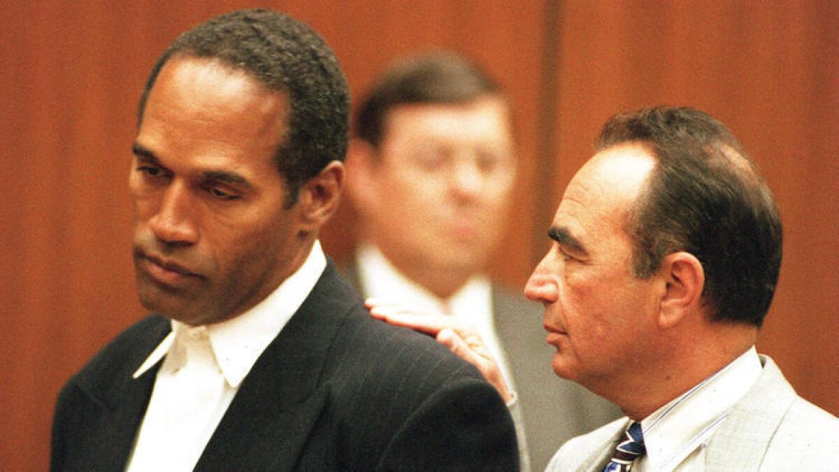 El abogado defensor Robert Shapiro con su cliente O.J. Simpson, en la primera lectura de cargos de la exestrella de fútbol americano, el 20 de junio de 1994.