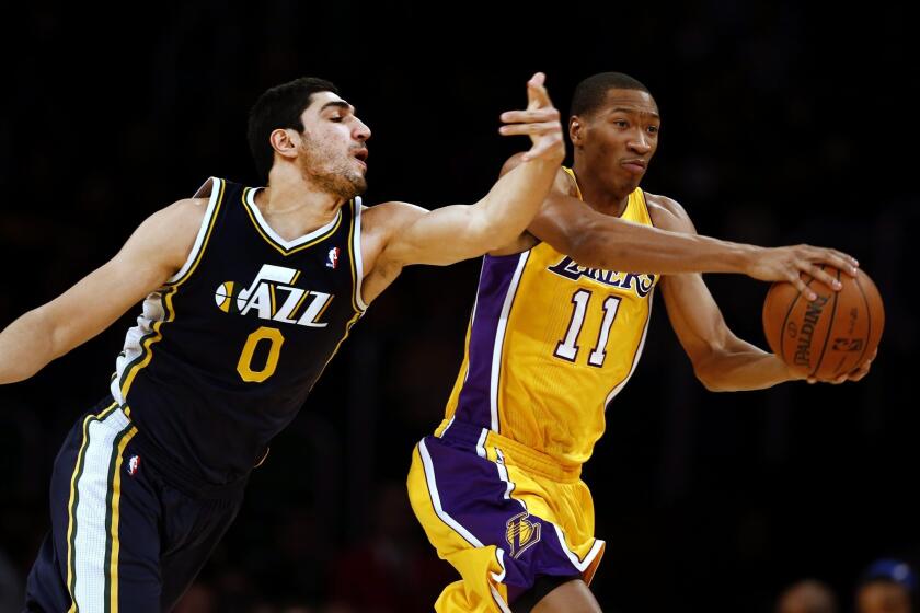 Lakers forward Wesley Johnson protects the ball from a steal attempt by Jazz center Enes Kanter during a game last season at Staples Center.