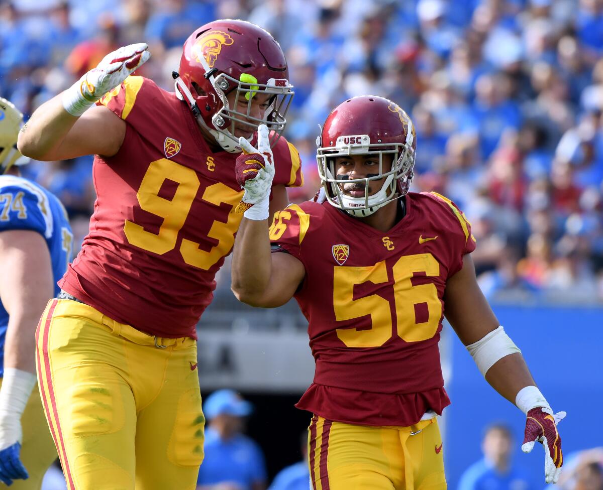 Jordan Iosefa (56) celebrates a sack with Liam Jimmons (93) during the first half of a game against the UCLA on Nov. 17, 2018 at the Rose Bowl. 