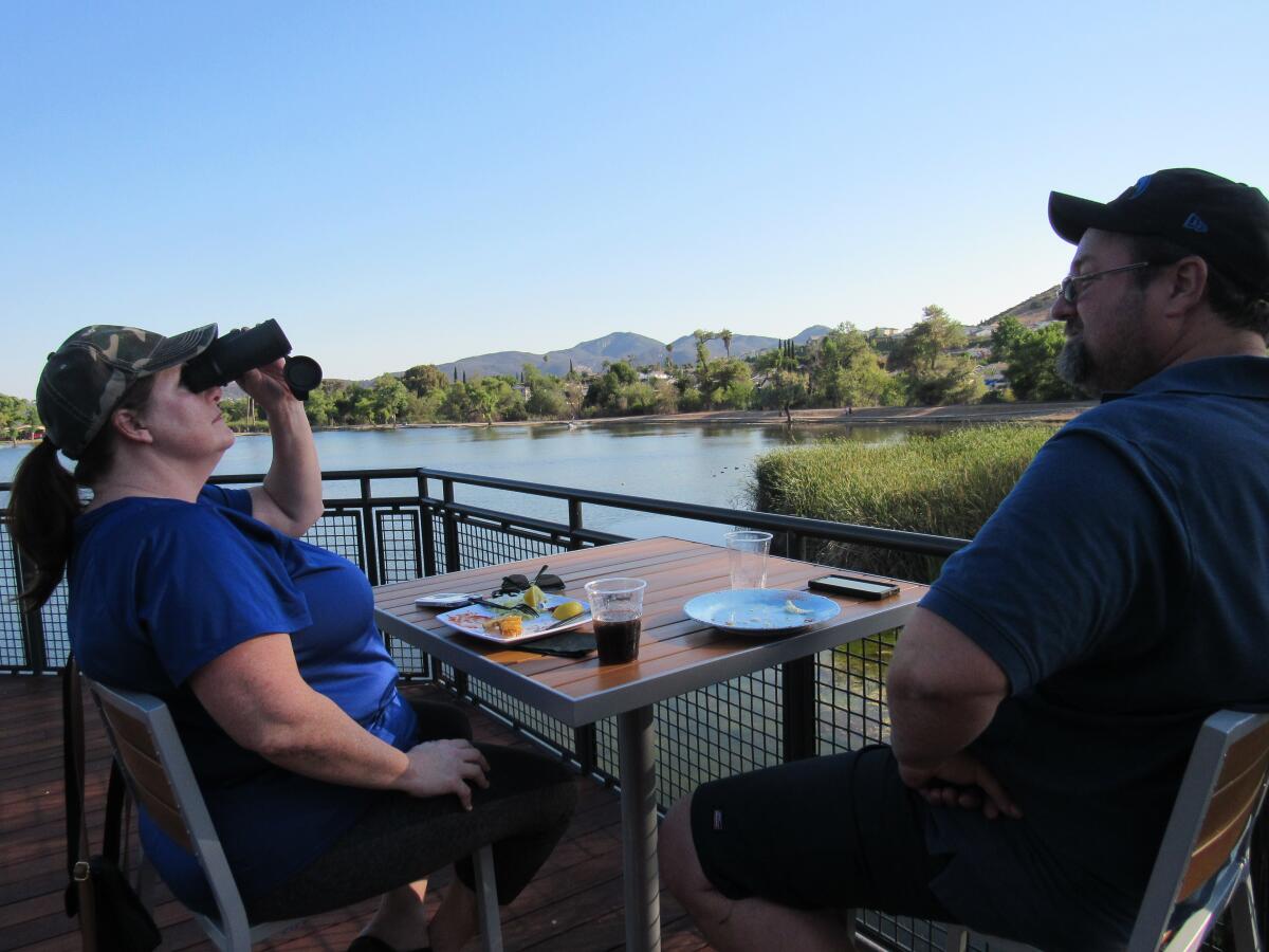 Marci Murray of Santee uses binoculars to check out some of the local birds at Santee Lakes with her husband, Dan.