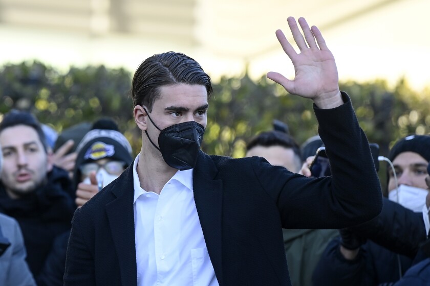 Coveted striker Dusan Vlahovic waves as he arrives for a medical at Juventus grounds in Turin, Italy, Friday, Jan. 28, 2022. Vlahovic was undergoing a medical on Friday to complete what is expected to be one of the biggest moves of the transfer window. (Fabio Ferrari/LaPresse via AP)