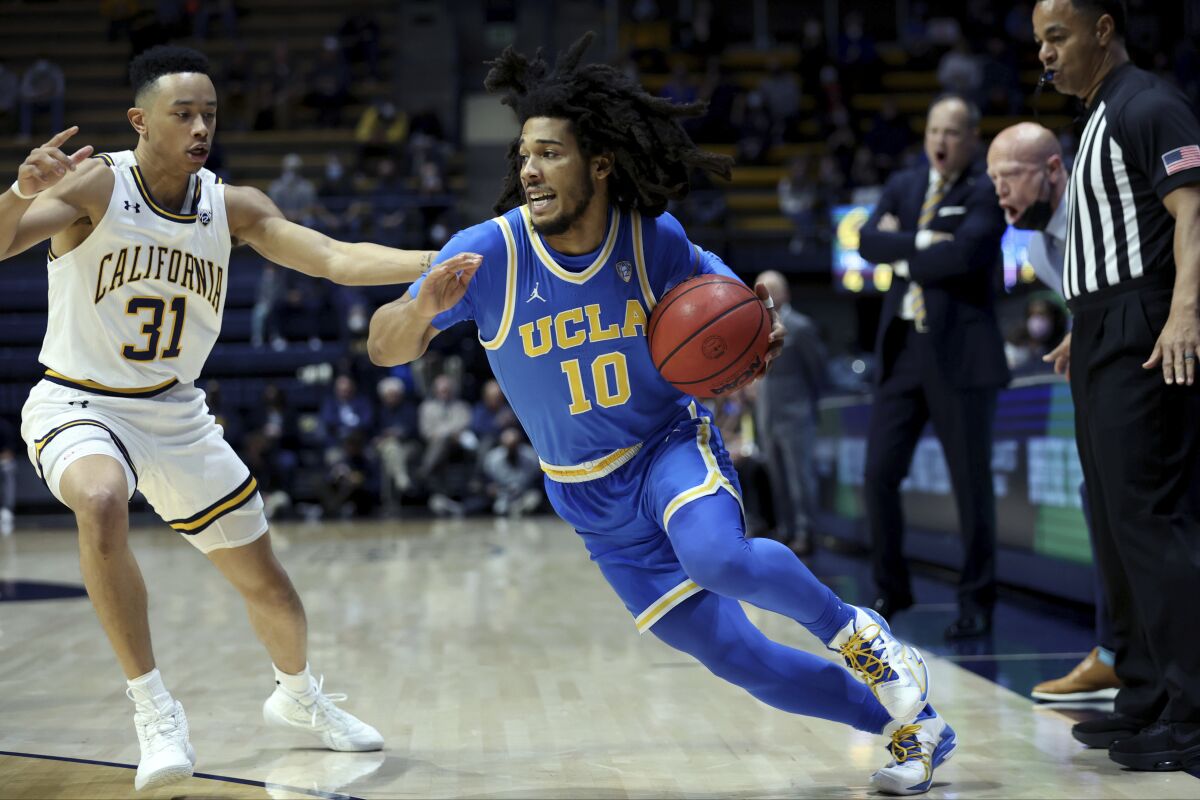UCLA guard Tyger Campbell, right, drives to the basket against California guard Jordan Shepherd.