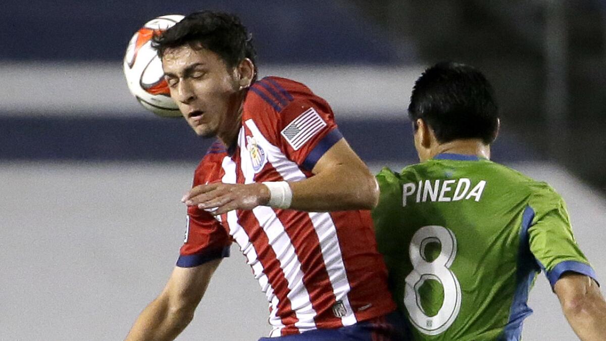 Chivas USA midfielder Marco Delgado, left, heads the ball away from Seattle Sounders FC midfielder Gonzalo Pineda during a match in April.