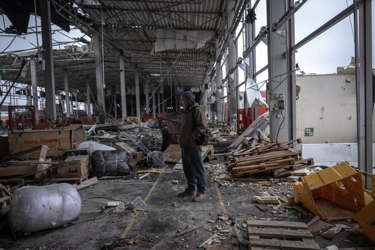A person stands in a damaged building in Ukraine.
