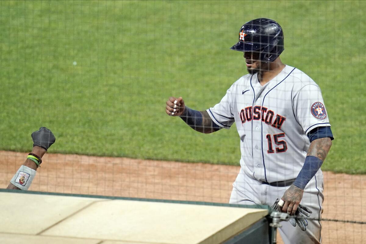 Houston Astros' Martin Maldonado (15) has a waiting fist-bump as he scores on a single by Michael Brantley in the ninth inning of a baseball game against the Minnesota Twins, Friday, June 11, 2021, in Minneapolis. (AP Photo/Jim Mone)