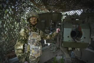 In this photo taken on Friday, April 26, 2024 and released by the Russian Defense Ministry Press Service, a Russian soldier poses for a photo next to a 2A65 "Msta-B" howitzer at a position in an undisclosed location in Ukraine. (Russian Defense Ministry Press Service via AP)