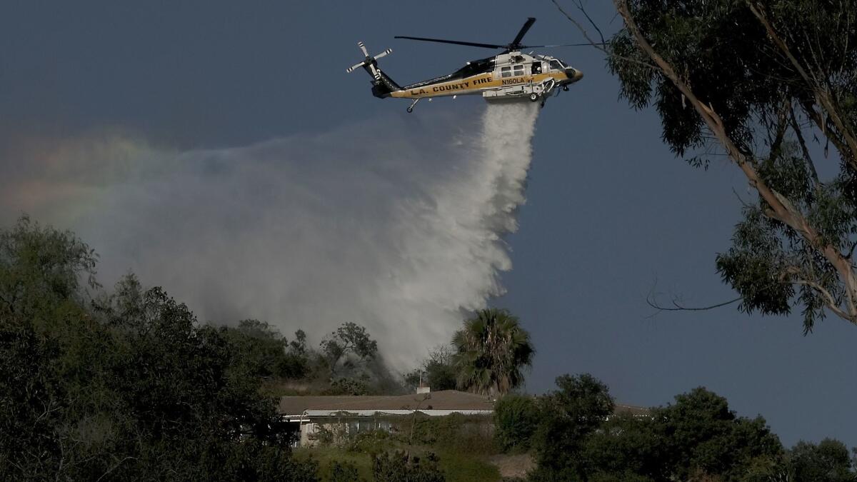 Firefighters battle a 20-acre brush fire that threatened homes and triggered voluntary evacuations in La Verne.