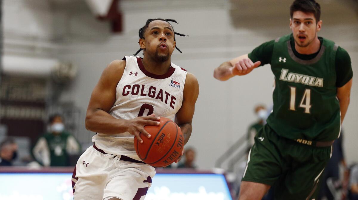Colgate's Nelly Cummings drives past Loyola's Alonso Faure.