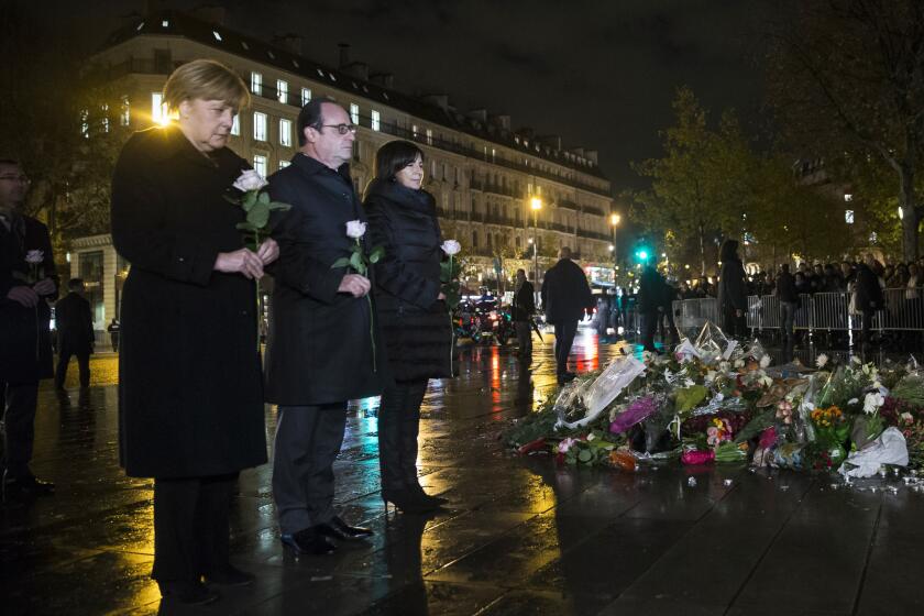 German Chancellor Angela Merkel, left, French President Francois Hollande and Paris Mayor Anne Hidalgo pay their respects to the victims of the Nov. 13 attacks on the Place de la Republique. A survey found that only 10% of business travel managers changed travel plans after the attacks.