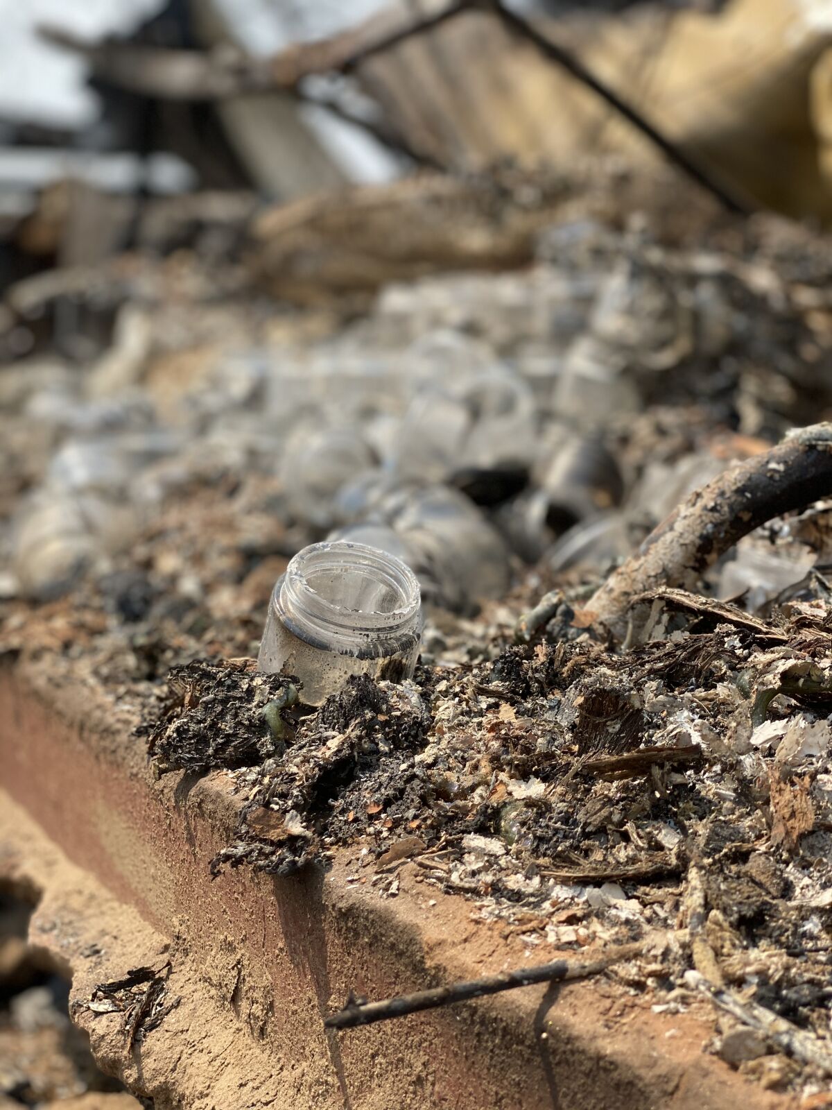 A glass jar among the ruins of No Boundaries Farm after the Valley fire