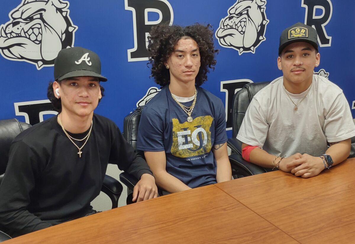 Football player Azlan Enriquez headed to Eastern Oregon University is shown with his brothers, Atticus, left, and Adrian.