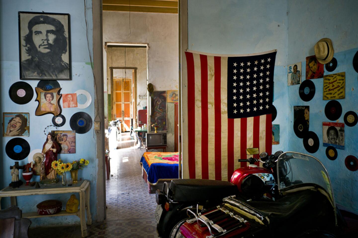 Una foto del revolucionario Ernesto "Che" Guevara est· en una pared y en la otra hay bandera de EEUU en una vivienda en La Habana, Cuba, el martes 15 de marzo de 2016. Cinco dÌas antes de que se realice el primer viaje de un presidente de EEUU a La Habana en casi 90 aÒos, el gobierno de Barack Obama le propinÛ una serie de golpes al embargo comercial a Cuba al convertir la prohibiciÛn de viajar a la isla en un sistema que depende de que las personas digan que el propÛsito de que su viaje es educativo, y no turÌstico, y al allanar el camino para que jugadores de bÈisbol, y otros atletas profesionales, puedan alg¿n dÌa jugar en las Grandes Ligas o en otras ligas profesionales estadounidenses. (Foto AP / RamÛn Espinosa)