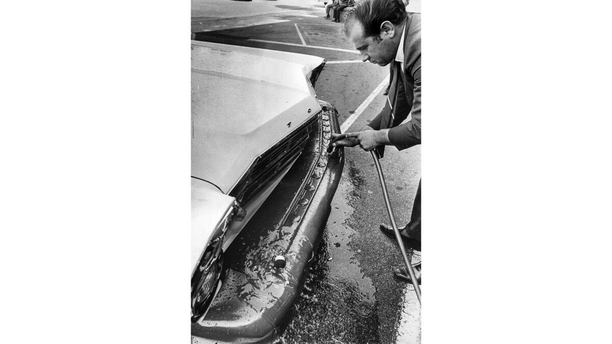 Sept. 12, 1967: Norm Hammond uses a hose to fill a car bumper with water.