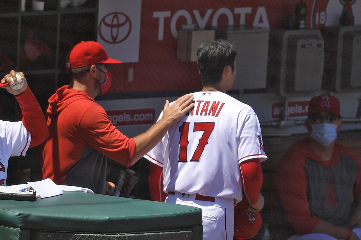 Angels starting pitcher Shohei Ohtani reacts after walking in a run against the Houston Astros.
