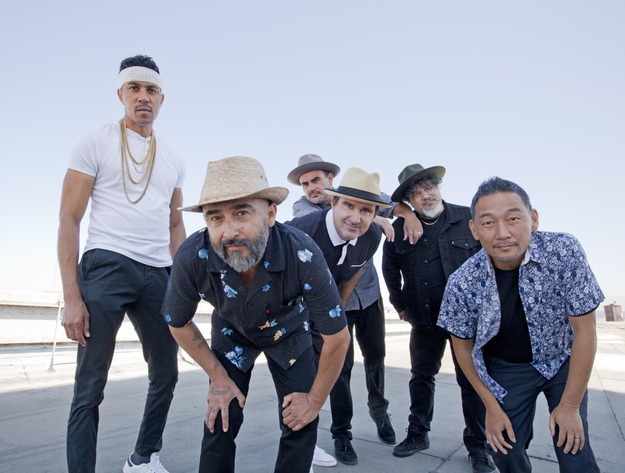 Six men, most wearing hats, most bending at the waist, looking at the camera