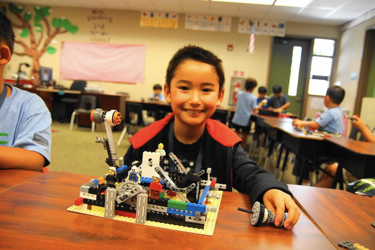 Student Harrison Stone constructs a robot during LEGO engineering class.